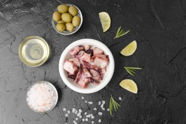 Ahtapot zeytinli, yağlı ve tuzlu siyah arkaplanda gurme malzemesi veya rustik pişirme konsepti için