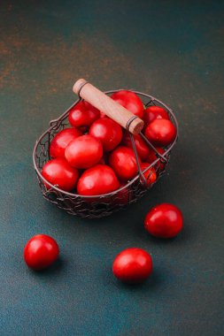 Taze yaz meyvesi veya sağlıklı yemek fotoğrafçılığı için kırsal tel sepet konseptindeki kırmızı erikler.