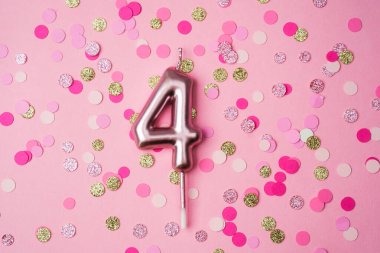 Canlı ekrana renkli konfetilerle çevrili dört numaralı mum sergileniyor..