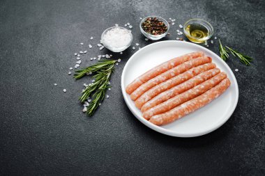 Beyaz tabakta taze domuz sosisi ve baharat.