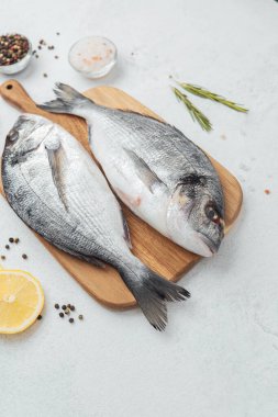 Dorado balığı domatesleri limon ve baharatları kesme tahtasına yakın.