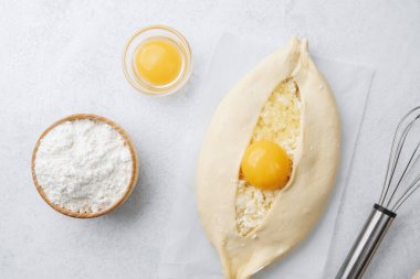 Yumurta sarısı ve beyaz arka planda çırpılmamış khachapuri.