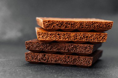 Koyu renkli sırtüstü havalanmış sütlü çikolata parçaları yığını.