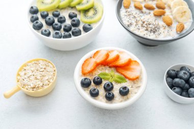 Beyaz arka planda çilekli yulaf ezmesi ve yaban mersini.