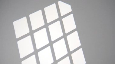 Güneş ışınları pürüzsüz gri bir duvarda güzel bir geometrik desen oluşturarak, sakin ve minimalist soyut bir arkaplan oluşturur..