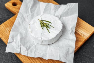 Ahşap bir tahtaya konmuş yumuşak peynirle kaplanmış..