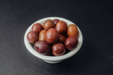 Siyah desenli masada kırmızı kalamata zeytinli kase.