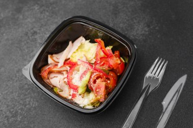 Sağlıklı öğle yemeği veya protein diyeti konsepti için marul domates kırmızı biber ve parmesan peynirli hindi salatası.