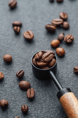 Koyu arkaplanda tam kaşık kahve çekirdeği.