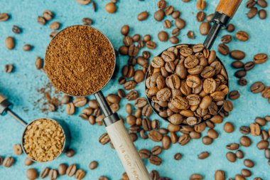 Kahve, hazır kahve ve mavi arka planda kepçelerle fasulye.