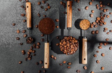 Koyu arkaplan üzerine kepçe ve kase şeklinde çeşitli kahve türleri.