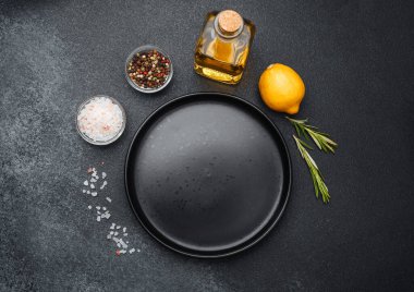 Limon, baharat, yağ ve tuz koyu bir arka planda pişirmek için düzenlenir..