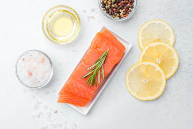 Düzgünce sergilenmiş limon dilimleri ve baharatlarla süslenmiş somon filetosu..