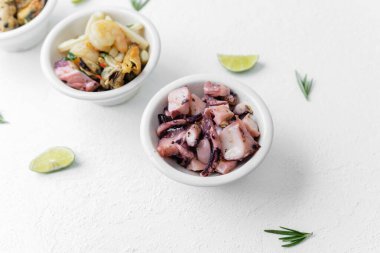 En az besin bileşimi ya da diyet konsepti için beyaz zemin üzerinde otlu ve limonlu üç deniz ürünleri kasesi.