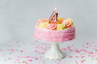 Güzel dekore edilmiş pembe bir pasta dördüncü doğum gününü kutlar..