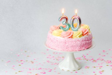 30 numarayı gösteren pembe bir doğum günü pastası kutlamaya hazır..