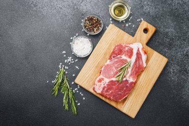 Biberiyeli çiğ biftek ve ahşap tahtada baharatlar.