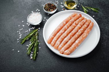 Beyaz tabakta taze domuz sosisi ve baharat.