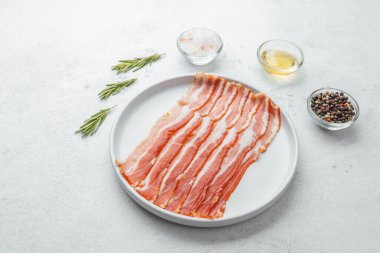 Pişmemiş pastırma şeritleri beyaz tabakta biberiye ve baharatla.