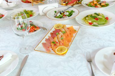 Taze malzemeli lezzetli suşi ve limonlu beyaz masa örtüsü..