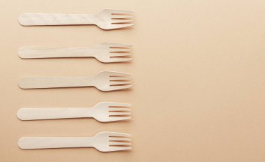 Pastel arka planda duran tahta çatallar.