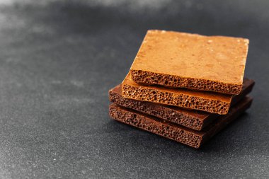 Koyu renkli sırtüstü havalanmış sütlü çikolata parçaları yığını.