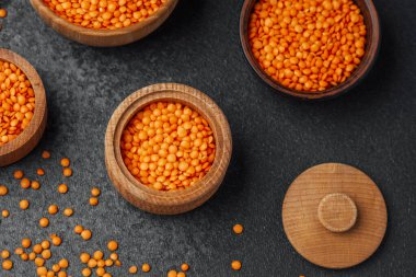 Renkli turuncu mercimekler ahşap kaselerde sergileniyor..