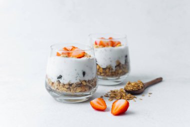 Dilimlenmiş çilek ve tahıl gevreğiyle kaplı yoğurt parfe.