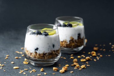 Koyu arkaplanda kivi ve yaban mersinli sağlıklı kahvaltı.