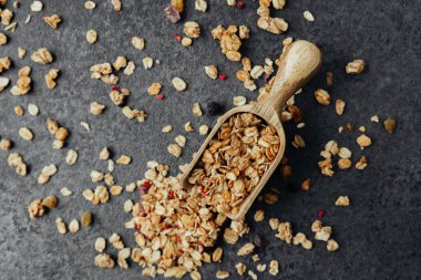 Dağınık yulaflı granola kepçesi siyah taş arka planda