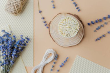 Mumlar malzemeler ve bej yüzeyde lavanta çiçekleri yapıyordu.