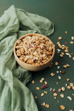 Dağınık yulaf ve yeşil tekstil ile üst manzara granola kasesi