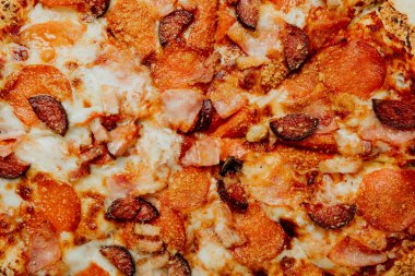 Biberli, sosisli ve kıtır jambonlu lezzetli bir pizza..