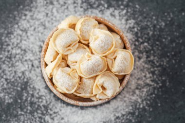 Ahşap kase un tozlu cappelletti makarna ile dolu.