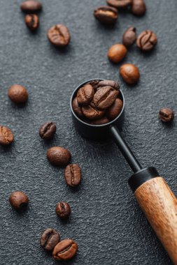 Koyu arkaplanda tam kaşık kahve çekirdeği.