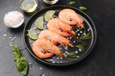 Biberiye, tuz ve zeytin ile servis edilen karides gurme aperatifler veya restoran menüsü konsepti için siyah tabakta