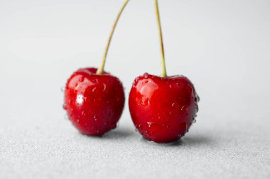 Minimalizm, malzeme veya meyve sağlığı kavramı için beyaza izole edilmiş iki kiraz.