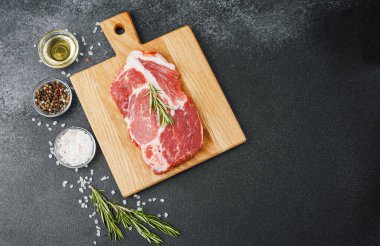 Biberiyeli çiğ biftek ve ahşap tahtada baharatlar.