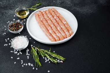 Beyaz tabakta taze domuz sosisi ve baharat.