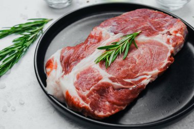 Biberiyeli domuz bifteği, siyah tabakta baharatlı.