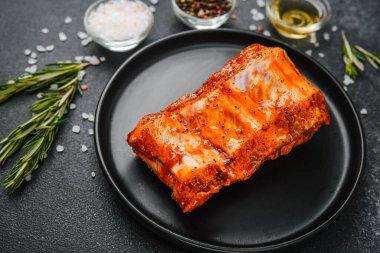 Biberiye ve tuzlu siyah tabakta baharatlı domuz kaburgası.