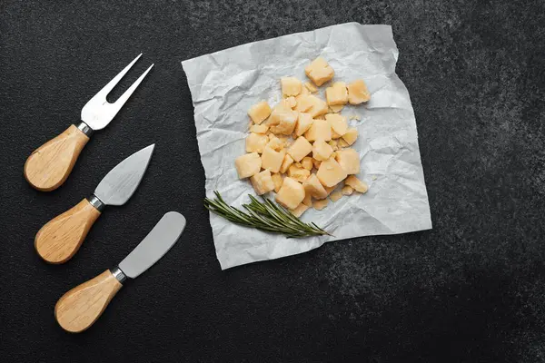 Peynir parçaları, yanında biberiye ve bıçaklarla parşömen üzerine dizilir..