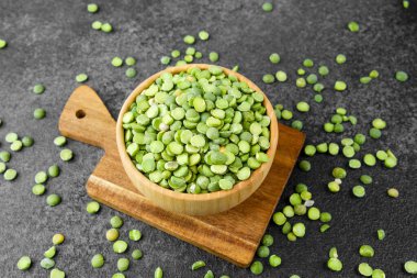 Güvertede yeşil bezelyeler var. Köy yemekleri, diyet malzemeleri veya yiyecek konsepti için dağınık taneler var.