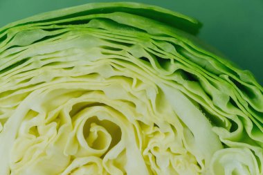 Yarım lahana üst görünümü düz yeşil arkaplan üzerinde yatıyordu