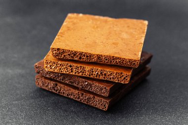 Koyu renkli sırtüstü havalanmış sütlü çikolata parçaları yığını.