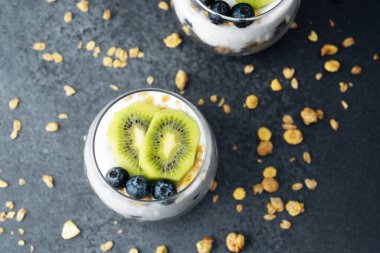 Koyu arkaplanda kivi ve yaban mersinli sağlıklı kahvaltı.