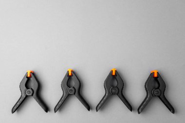 Gri arka planda turuncu uçlu siyah plastik kıskaçlar.