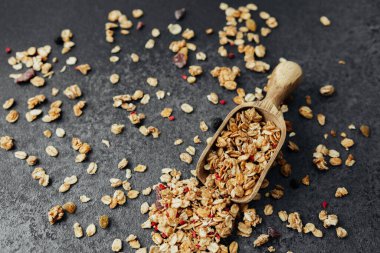 Dağınık yulaflı granola kepçesi siyah taş arka planda