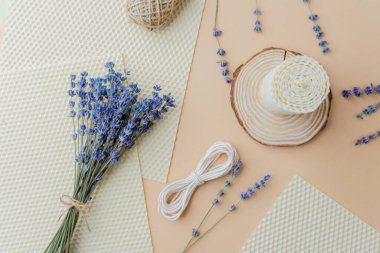 Mumlar malzemeler ve bej yüzeyde lavanta çiçekleri yapıyordu.