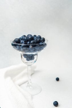 Sulu yaban mersinleri beyaz bir yüzey üzerinde kristal bir kasede zarif bir şekilde düzenlenir..